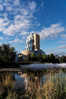 Front lake with artificial fog, Luma, 56 m high irregular tower designed by Frank Gehry, tower in