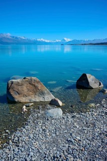 Large boulders on a sunny lake with mountain backdrop, Lake Pukaki Viewpoint, Pukaki, Canterbury,