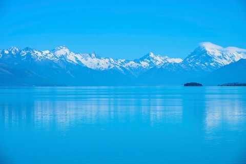 Calm lake with snow-capped mountains Mount Cook and a small island in the background, Lake Pukaki