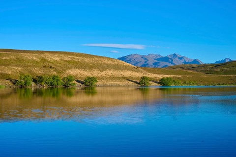 Blue sky over a calm lake with mountains in the background, Lake McGregor, Tekapo, Canterbury,