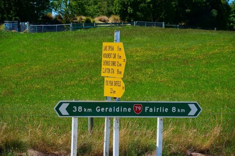Road signs with distances on green background in rural area, Geraldine, Canterbury, South Island,