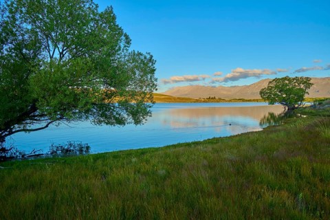 Peaceful landscape with lake views, trees and soft evening colors in the sky, Lake McGregor,