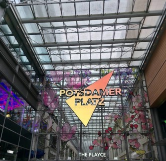 Colourful glass façade with lettering in the covered atrium on Potsdamer Platz, floral patterns and