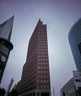 Dramatic upward view of modern skyscrapers on Potsdamer Platz under grey skies, at Potsdamer Platz