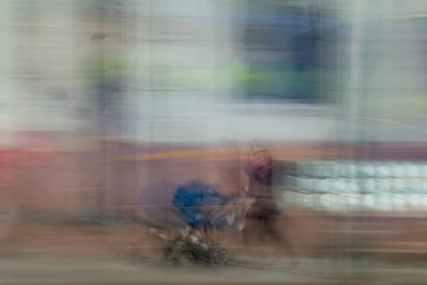 Abstract image of a woman pushing a pram in city captured using ICM intentional camera movement