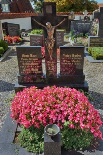 Graves with crucifix and floral decoration in Maria-Thann, Allgäu, Swabia, Bavaria, Germany