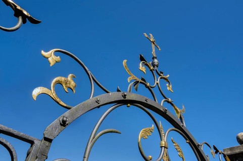 Blue sky and wrought iron gate to the cemetery in Maria-Thann, Allgäu, Swabia, Bavaria, Germany