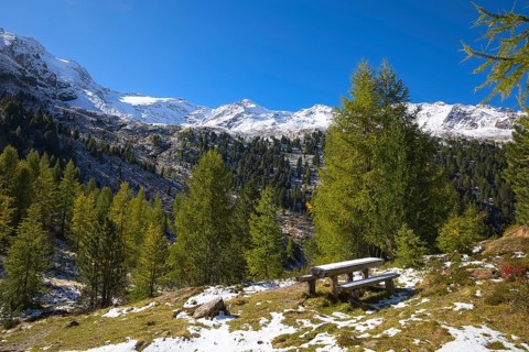 Wooden benches and a table invite hikers to rest in the mountains in the Vinschgau Valley in Italy