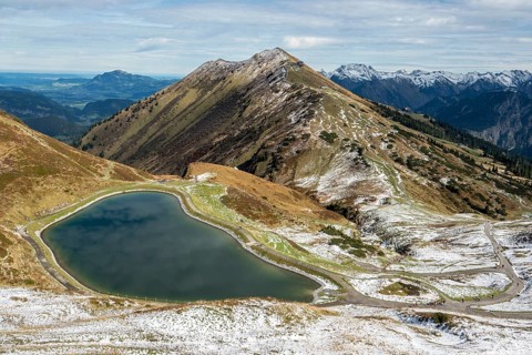 Reservoir, Kanzelwand snow-making pond, behind Fellhorn and mountains of the Allgäu Alps,