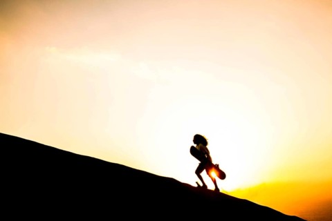 Silhouette of a sandboarder walking on the dunes of Caramucho, in Atacama Desert. Iquique, Tarapaca