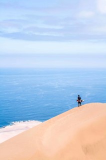 Young man looking at the view from Alto los Verdes, in Atacama Desert. Iquique, Tarapaca Region,