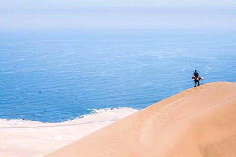 Young man looking at the view from Alto los Verdes, in Atacama Desert. Iquique, Tarapaca Region,