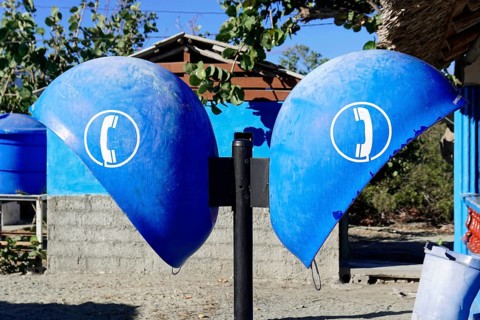 Baracoa, Cuba, Central America, Two blue public telephone boxes under bright sunshine, in front of