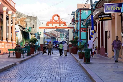Baracoa, Cuba, Central America, Busy street with many people and colorful colonial buildings,