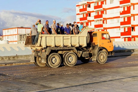 Baracoa, Cuba, Central America, Open truck loaded with workers on a wide, empty road, Greater