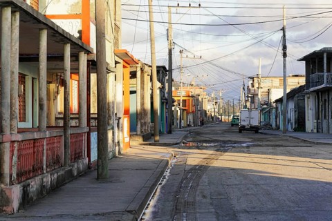 Baracoa, Cuba, Central America, Deserted street with empty sidewalks and visible old buildings,