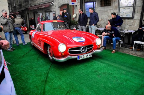 Roter 300 SL rolls across the green carpet through the old town, shiny chrome and rally number,