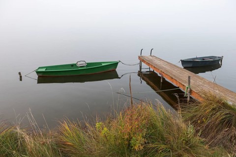 Two boats and a jetty in a misty seascape, Hopfensee, Ostallgäu, Bavaria, Germany