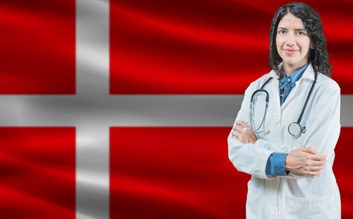 Danish medicine and healthcare concept. Close up of doctor against Denmark flag background