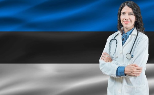 Estonian medicine and healthcare concept. Close up of doctor against Estonia flag background