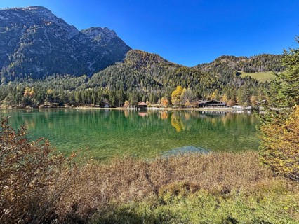 Calm lake with mountains in the background and colorful autumn leaves, Lake Toblach, Lake Dobbiaco,