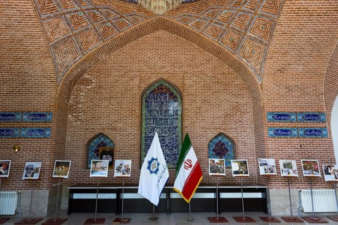 Interior with brick arch and exhibited photos with flags, Blue Mosque, Shiite Mosque, symbol of