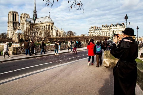 Tourists on Pont de l'Archevêché and Notre Dame Cathedral (Cathedrale Notre Dame de Paris) in the
