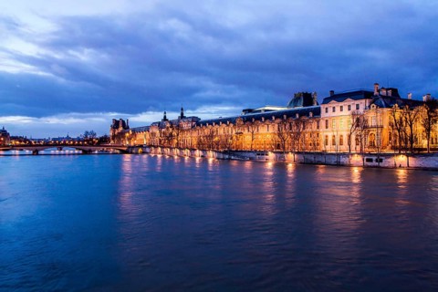 Seine River and Louvre Palace (Palais du Louvre) viewed from Pont des Arts at evening. Paris,