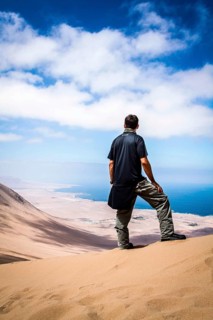 Young man looking at the view from Alto los Verdes, in Atacama Desert. Iquique, Tarapaca Region,