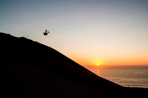 Sandboarding in Cerro Dragon, a sand dune located next to the city of Iquique, in Atacama Desert.