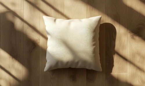 A beige pillow on a wooden floor with sunlight casting intricate shadows. AI generated