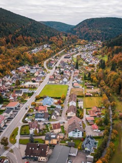 Aerial view of an elongated valley with autumnal foliage and urban development, Calmbach, Bad
