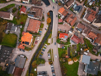 Aerial view of a village from above, showing roads, houses, a river and autumn trees, Calmbach, Bad