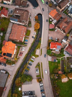Aerial view of a village with a river running between autumn trees and houses, Calmbach, Bad