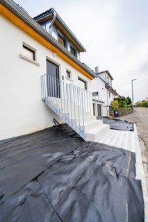 Straight-lined entrance with metal railing and dark door, functional and functional design, house