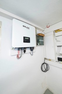 Wall-mounted SOLAX inverter in bright technical room, house renovation, climate renovation,