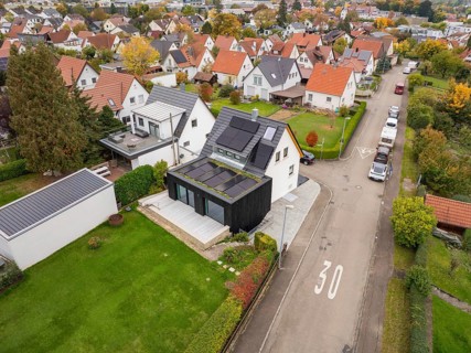Overview of a quiet residential area with modernized house with solar system and dark extension on