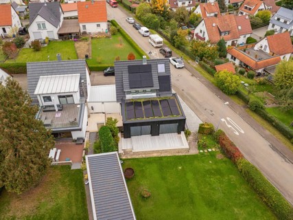 Vertical aerial view highlights the spacious wooden terrace at the extension and the orderly garden