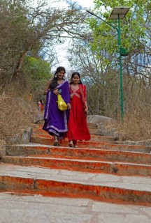 Young Indian woman on the red steps to Chamundi Hill, Mysore or Mysore, Karnataka, India
