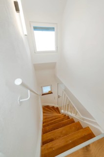 Narrow staircase with wooden steps and white railing, clear and tidy, house renovation, climate