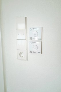 Wall panel with light switches, power outlet and smart home control in simple white, house