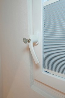 Detail of a white window handle with integrated blind, clean and modern, house renovation, climate