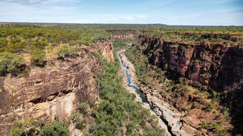 A calm creek flowing through a canyon in the Australian outback, photographed with a drone