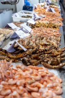 A stand selling fish at a market. Beautifully presented and shelved Fish buyers at Mercado Central