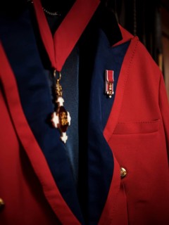 A riding jacked adorned with commemorative medals hang in the tack room at the Toronto North York