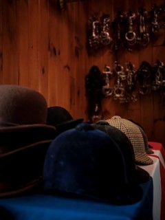 The tack room at the Toronto North York Hunt Club displaying a number of riding helmets, hats and a