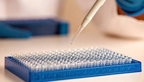 Droplet falls from pipette toward a blue 96-well plate, Pipette dispensing a liquid onto a