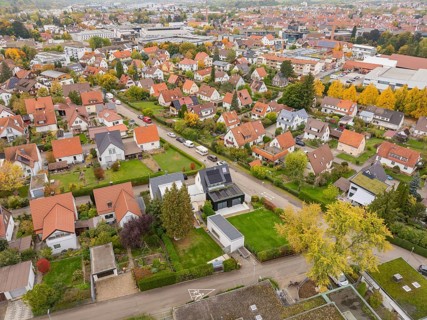 Autumn settlement with yellow tree avenue and view of the city under grey clouds, Metzingen,