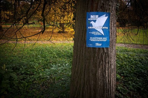 Poster on a tree trunk, call for a demonstration against war, peace demo, dove of peace, day of