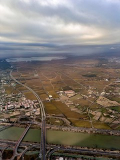 Turia flood canal with CV-500 road bridges, Albufera lagoon behind, aerial view, Valencia, Spain